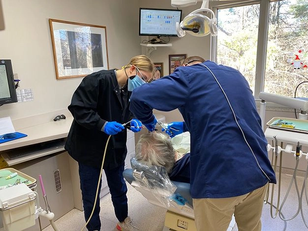 Dr. Adam and Caroline treating a patient with modern technology